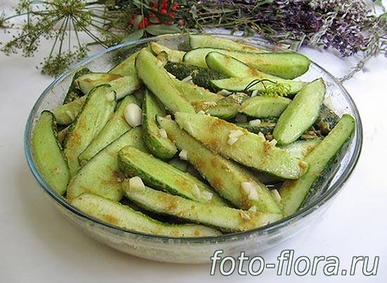 на фото порезанные огурцы дольками с горчицей, чесноком, маслом и специями